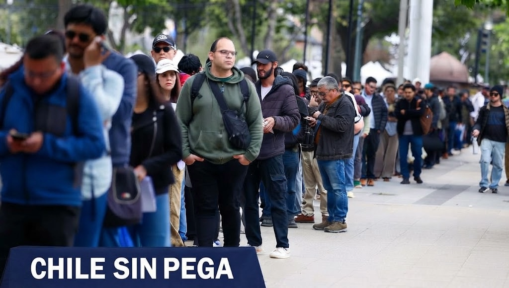 Larga fila de personas buscando empleo, con un cartel que dice Chile Sin Pega