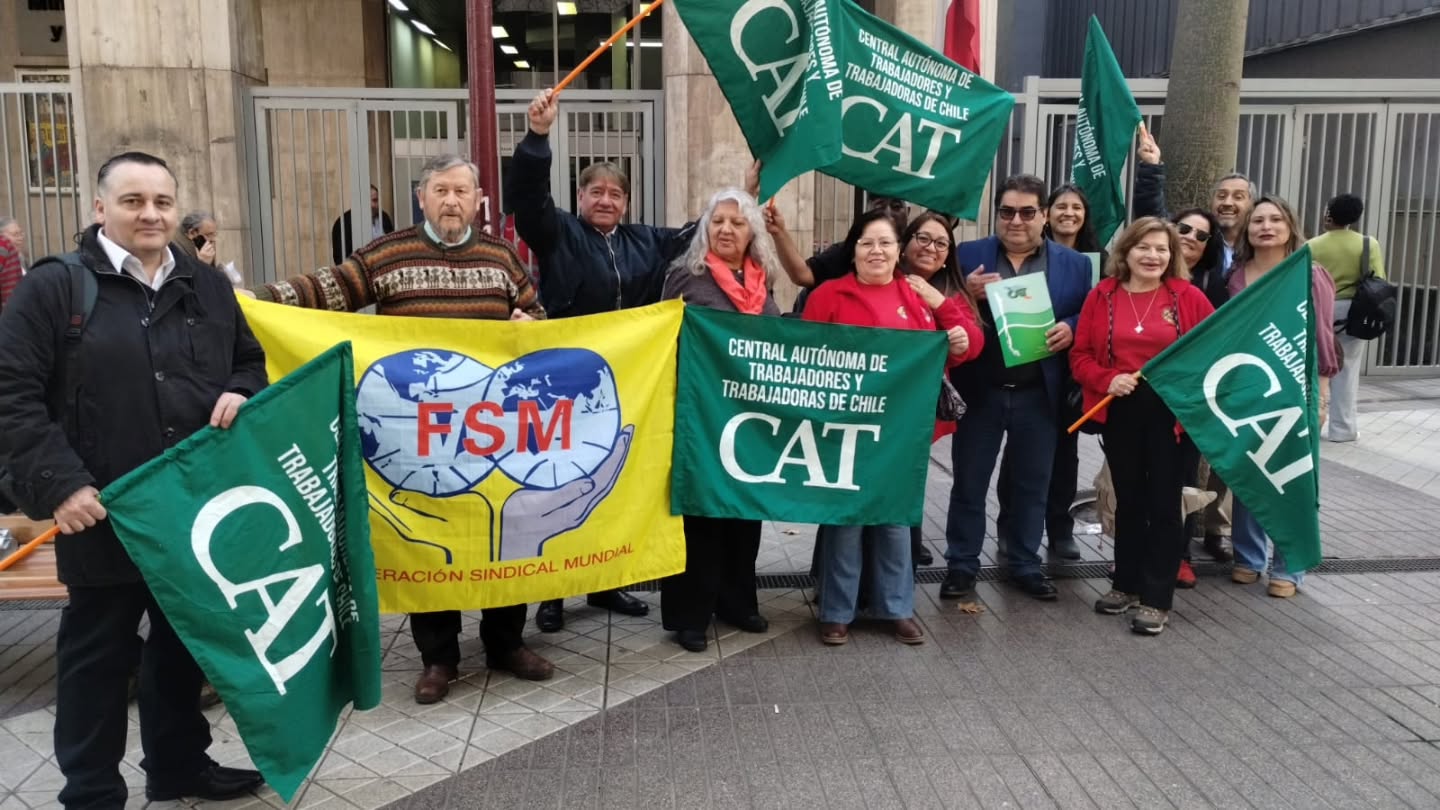 Delegación de la Central Autónoma de Trabajadores y Trabajadoras de Chile con sus banderas y la bandera de la Federación Sindical Mundial