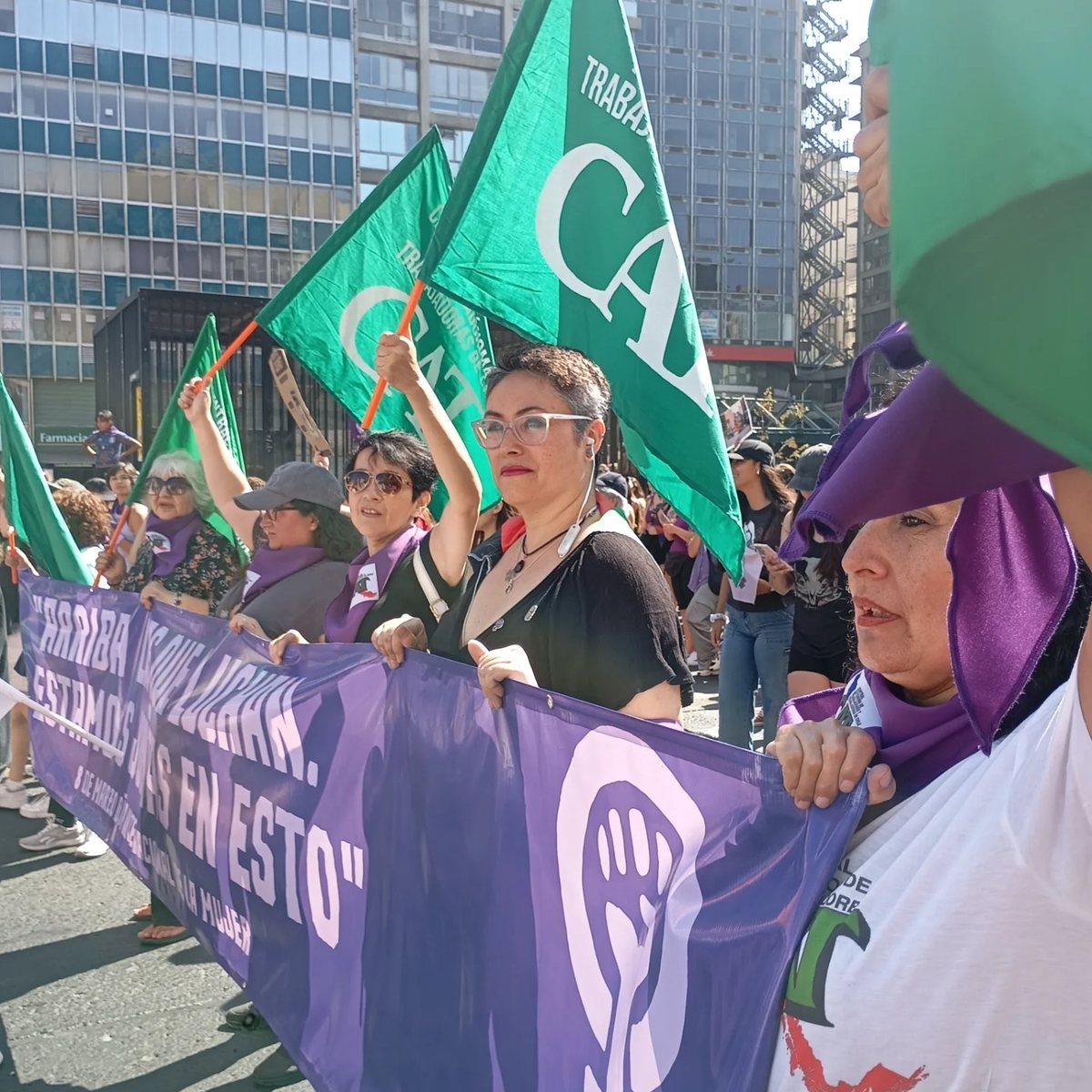 Trabajadoras de la CAT marchan con banderas verdes de la central y un lienzo morado que dice «Arriba las que luchan. Estamos unidas en esto», en la marcha del 8 de marzo